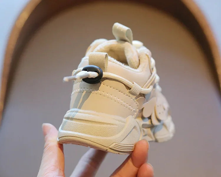 Young boy proudly showing off his new blue plush waterproof sports sneakers with elastic closure