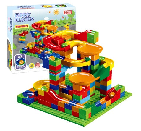 Child's hands excitedly placing a marble into a newly built marble run track, engaging developmental and educational toy