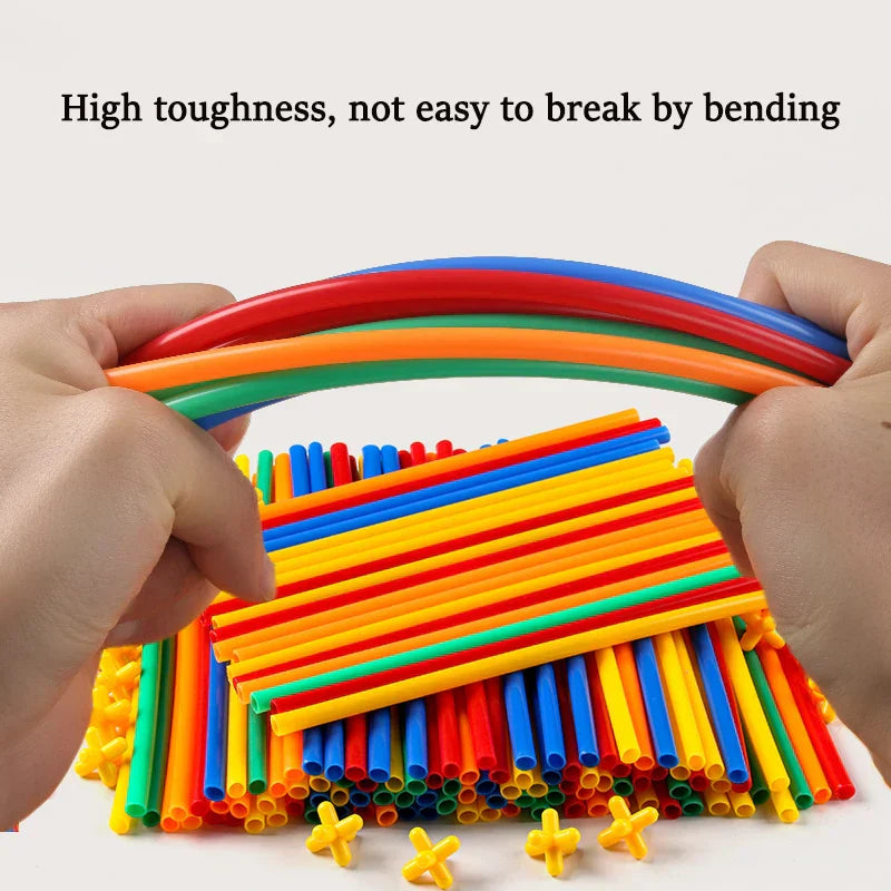 Close-up of a child's hands assembling a structure with a straw building set, enhancing fine motor skills.