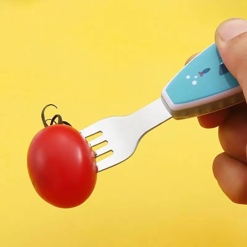 Toddler using a colorful cartoon spoon from the self-feeding set to eat mashed food