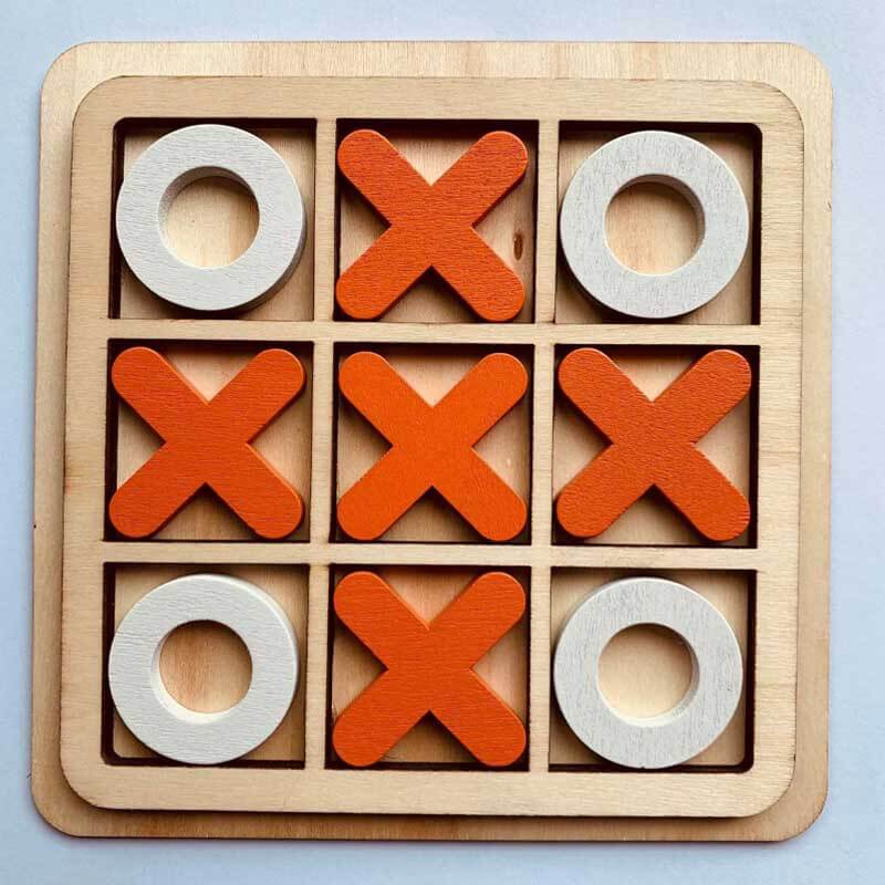 A child playing with a wooden Tic Tac Toe game, demonstrating the engaging and classic appeal of this board game.