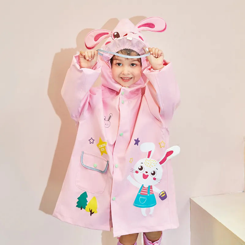 Toddler girl in a cute pink rabbit raincoat, ready for outdoor play in fall