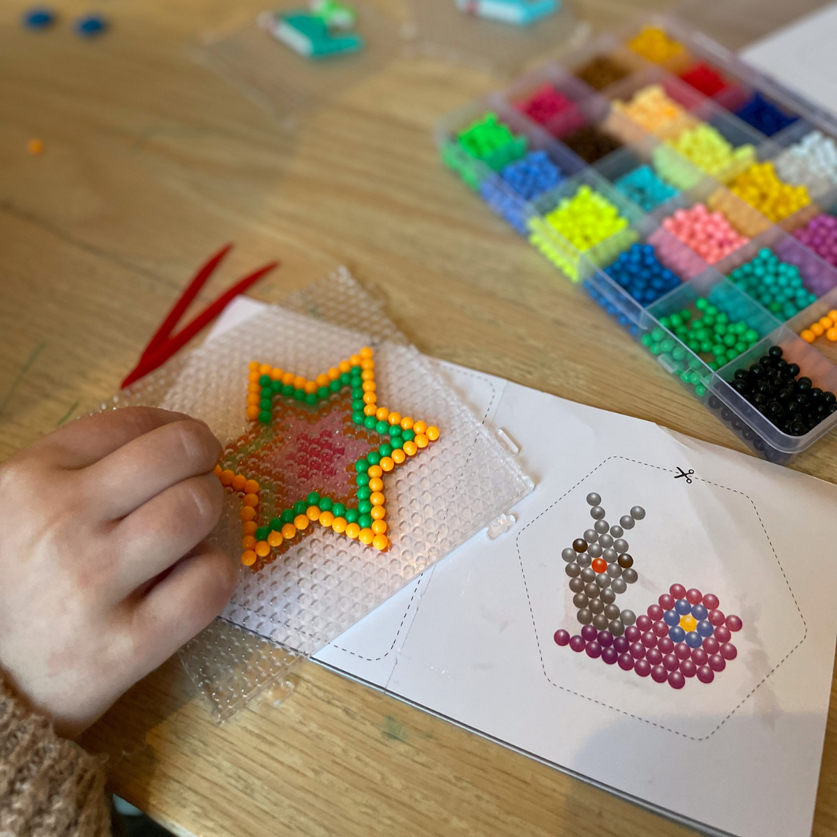 Water Fuse Beads craft kit for kids, colorful beads being arranged on a star-shaped pegboard