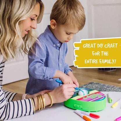 Easter egg decorating station with a blue spinner, instruction manual, and multiple colored pens.