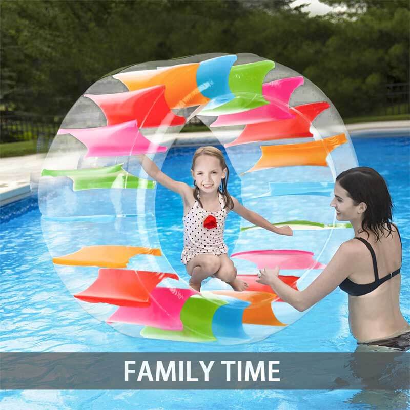 Kids playing with a large rainbow inflatable water wheel roller in a pool, ages 5-13