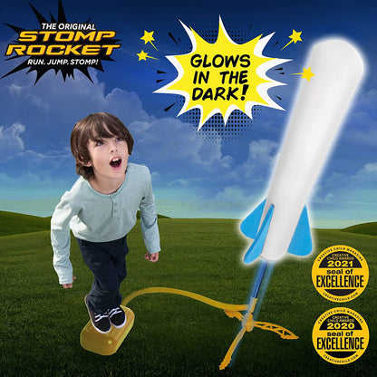 Close-up of a child's foot stomping on the pump of an Air Power Rocket Launcher, sending a rocket flying