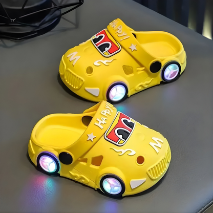 Close-up of children's play shoes featuring a red car design and illuminated LED lights