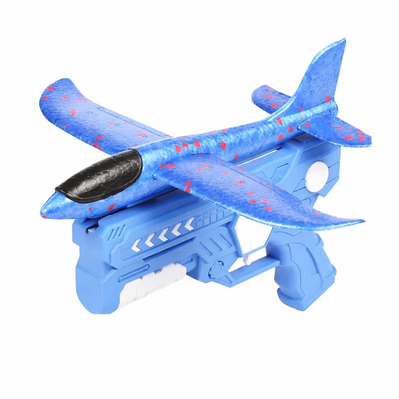 Young boy playing with a foam airplane launcher toy outdoors, engaging in active play