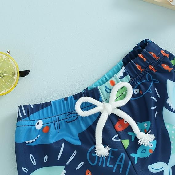 Boys' patterned swim shorts drying on a line, durable polyester for active summer play.