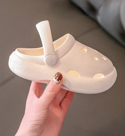 Pair of kids non-slip beach clogs on a towel, ready for summer fun