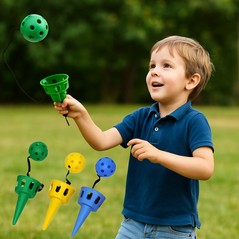 Kids playing outdoor toss and catch game with red paddles and yellow ball, active group fun