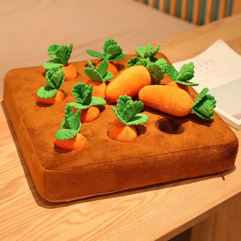 Unisex kids' hands interacting with a felt carrot and dirt patch, a sensory harvest plush toy