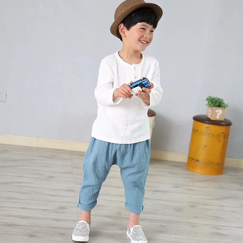 Toddler modeling a simple white kids' pleated linen & cotton blend t-shirt, boys shirt style