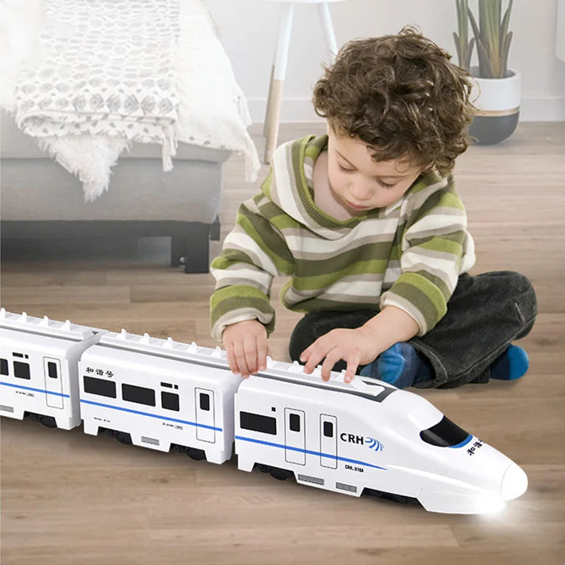 Toddler playing with a green self-propelled toy train with lights, promoting motor skills development