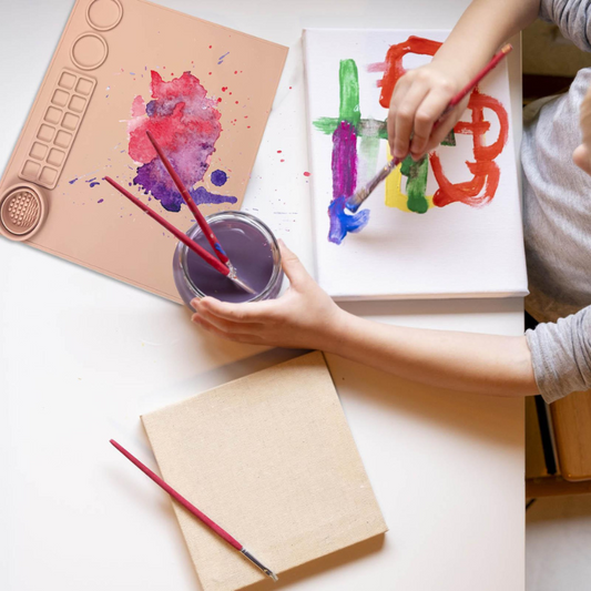Kids' red silicone art mat with paint and brushes, promoting mess-free creative play and easy cleanup.
