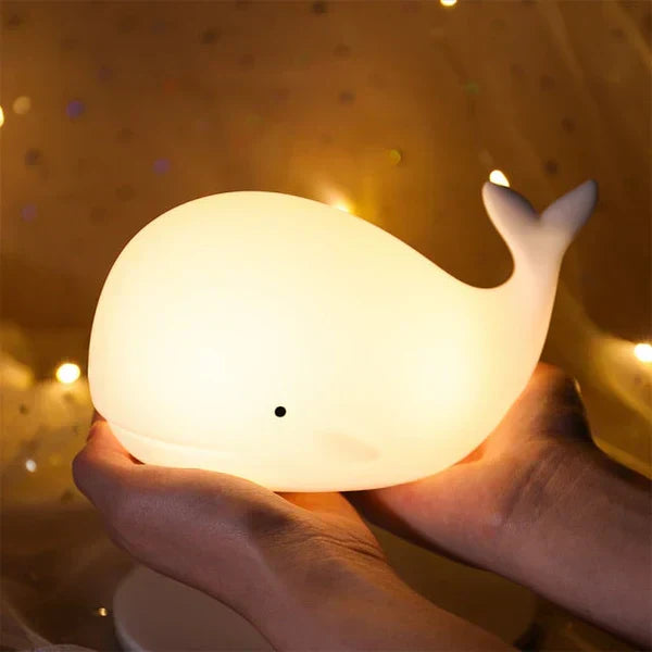 Whale-shaped touch lamp for kids. Soft, color-changing silicone night light enhances nursery & bedtime.