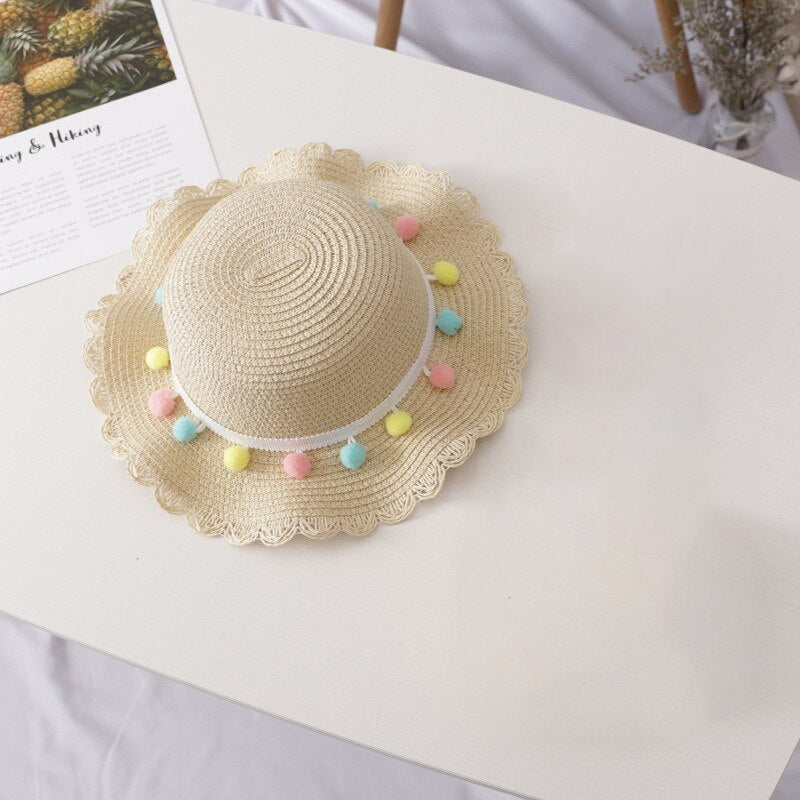 Toddler straw sun hat with wide brim paired with a cute straw bag, great for sunny day outings.