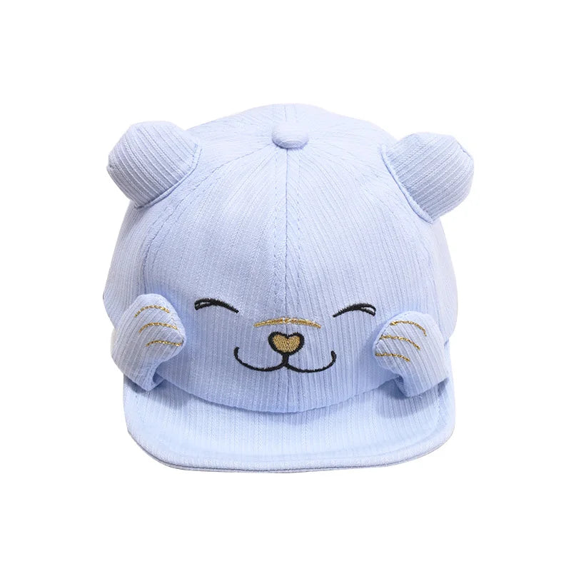 Child smiling while wearing a light blue adjustable cotton cap, protecting from sun