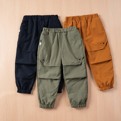 Happy child wearing unisex nylon cargo overalls, ready for spring adventures