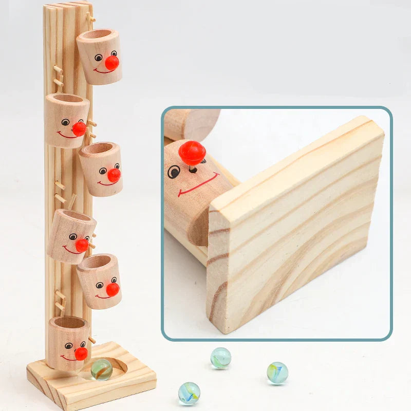 Close-up of a kids wooden clown ball track with a rolling red ball, showcasing craftsmanship