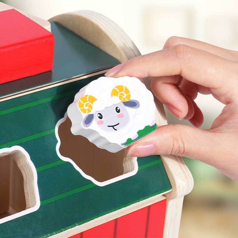 Toddler playing with wooden farm animal sorting barn, preschool learning activity toy