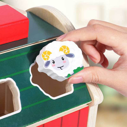 Toddler playing with wooden farm animal sorting barn, preschool learning activity toy