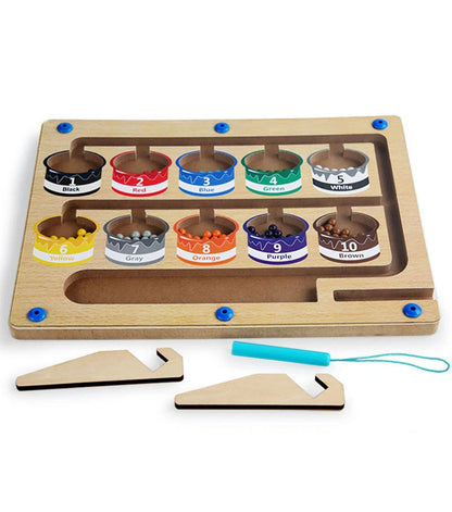 Close-up of a child guiding magnetic balls through a number maze board, enhancing fine motor skills