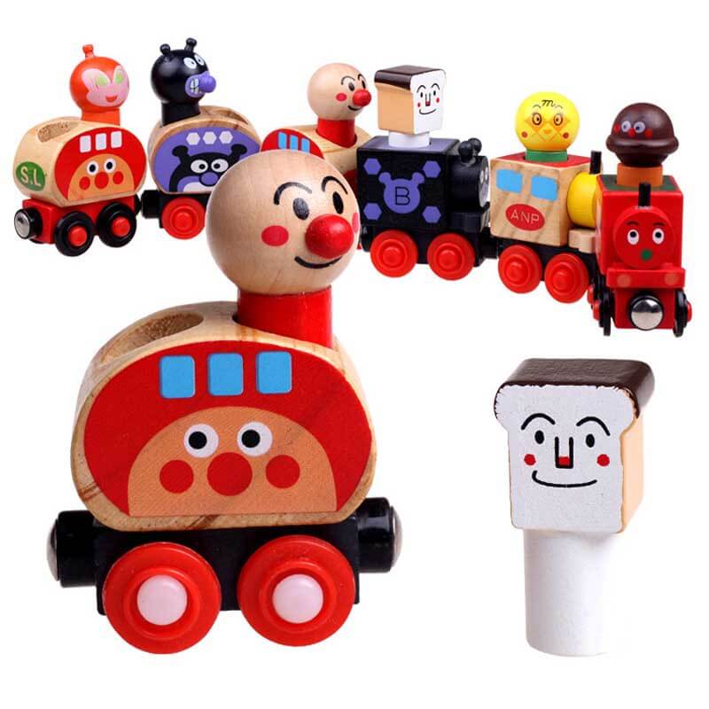 Toddler playing with wooden magnetic train set featuring colorful cartoon character carriages