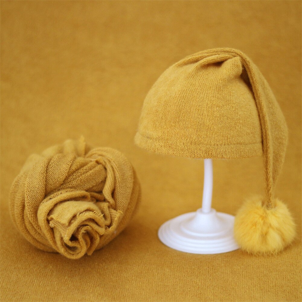 Chic knitted baby swaddle & fur ball hat, perfect accessory for infant photos.
