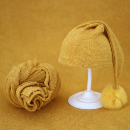 Chic knitted baby swaddle & fur ball hat, perfect accessory for infant photos.