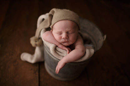 Newborn knitted baby wrap and fluffy fur ball hat, ideal for memorable baby photos.
