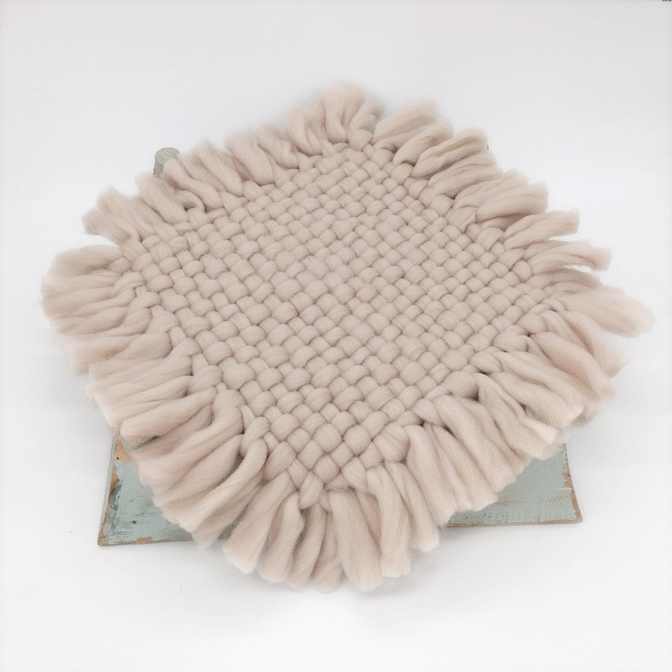 Small infant on a knitted baby blanket, showcasing product as a comfortable newborn photography prop