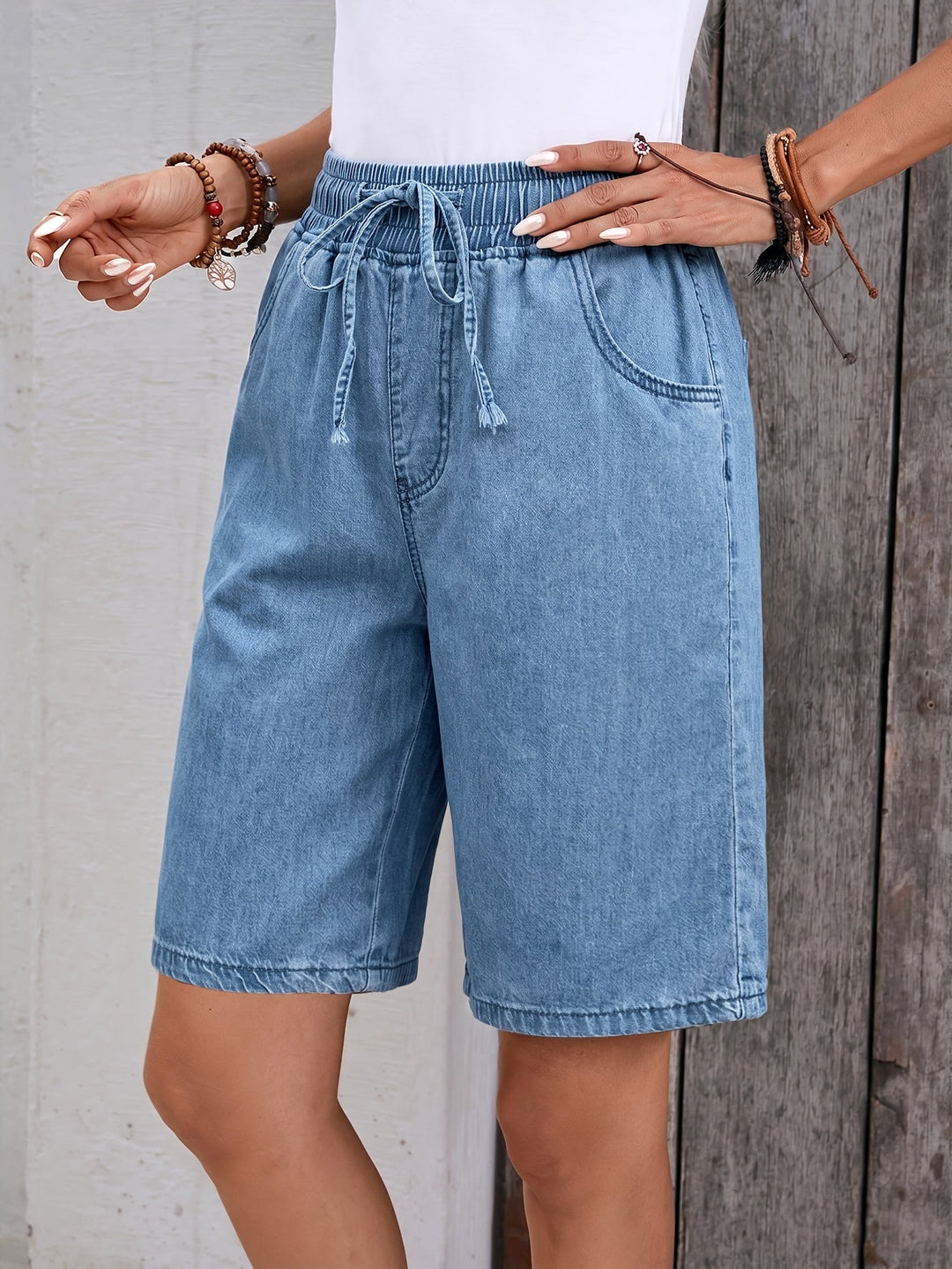 Casual light blue women's bermuda jean shorts with a drawstring elastic waist, ideal for summer fashion and relaxed outings.