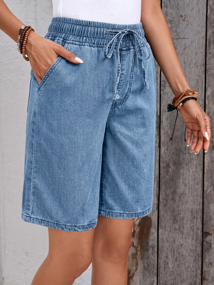 Women's light blue wide-leg bermuda jean shorts, offering a comfortable elastic drawstring waist for easy summer style.