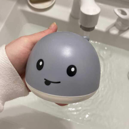 Light-up whale bath toy for toddlers with water spray feature, perfect for sensory water play.