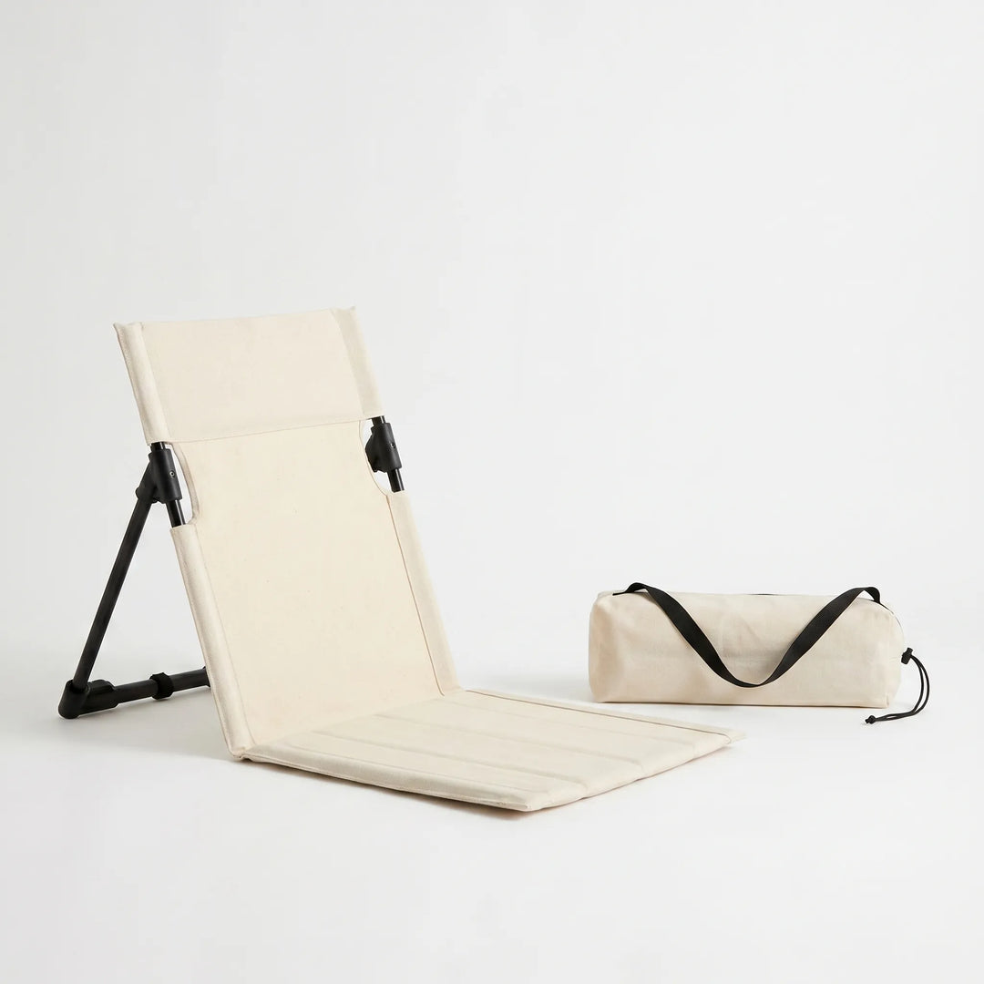 Low profile ground seat with adjustable backrest, providing comfortable support for outdoor activities like fishing.