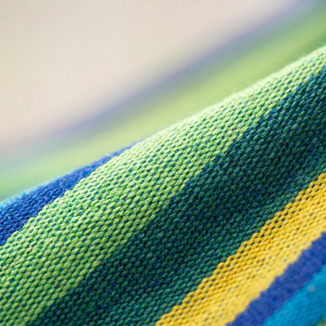 Relaxing single portable outdoor hammock, featuring durable striped canvas for garden, camping, or travel comfort.