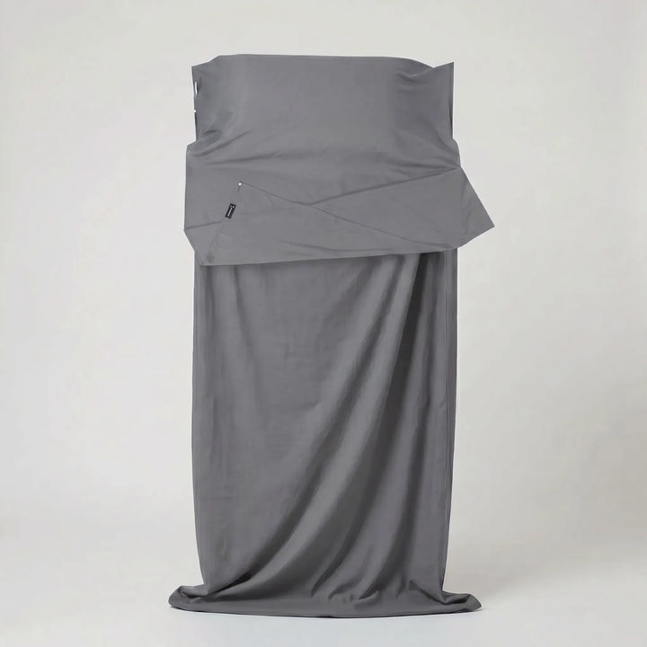 Lightweight, compact travel sleeping bag liner packed in its pouch, ready for camping, hostels, and outdoor adventures.