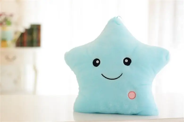 Kids' luminous star plush pillow in a cozy bedroom setting, glowing gently as a night light.
