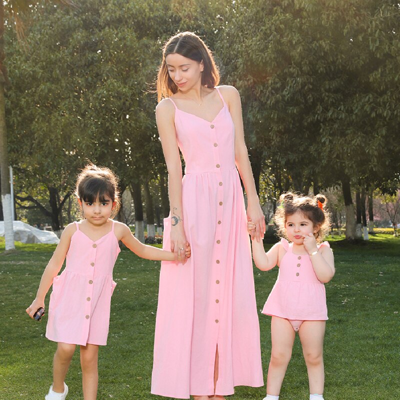 Matching family strapless button dresses and baby rompers, ideal for summer beach wear