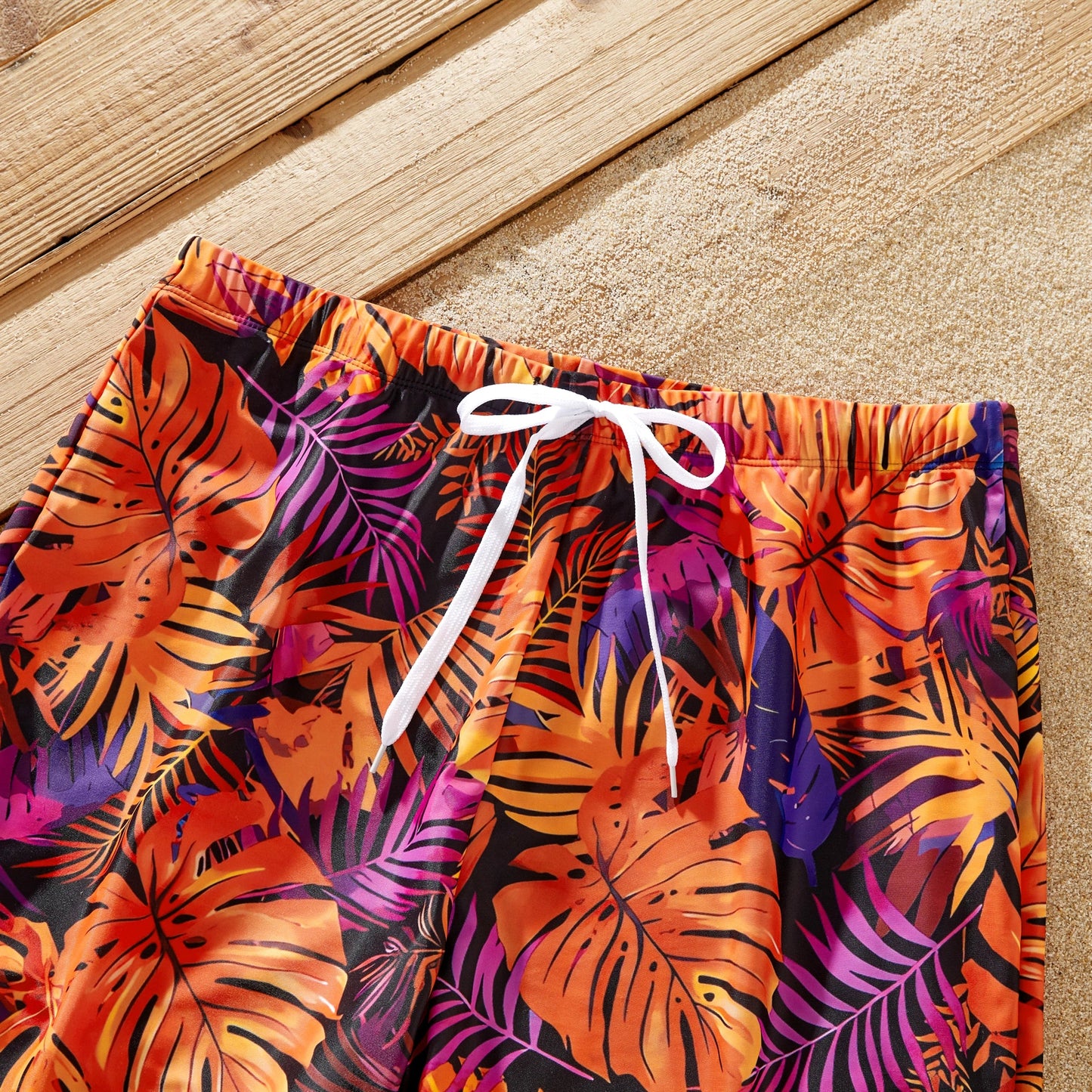 Close-up of vibrant floral print on matching family tropical swimsuits.