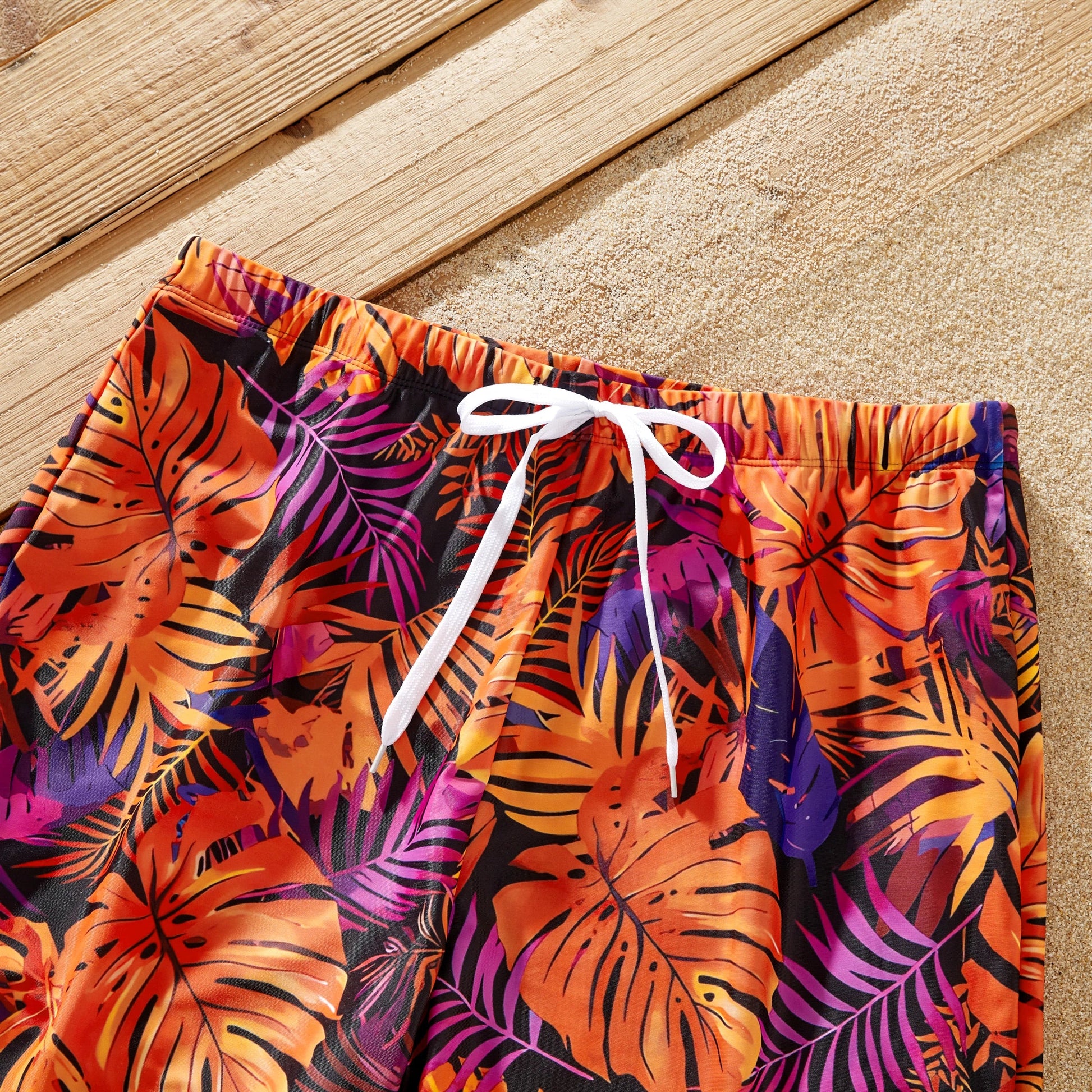 Close-up of vibrant floral print on matching family tropical swimsuits.