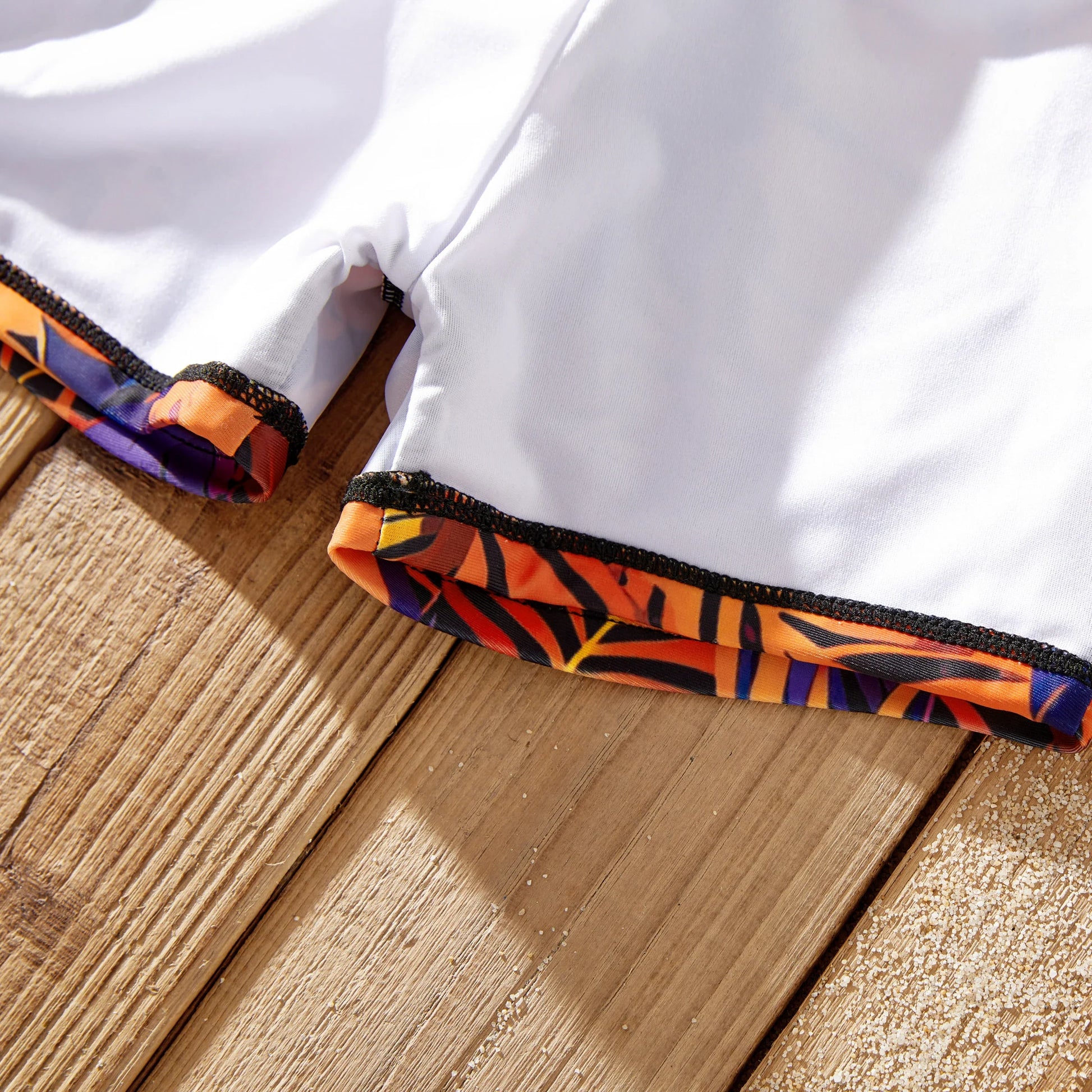 Men's floral swim trunks with drawstring detail. Comfortable fit for beachwear.