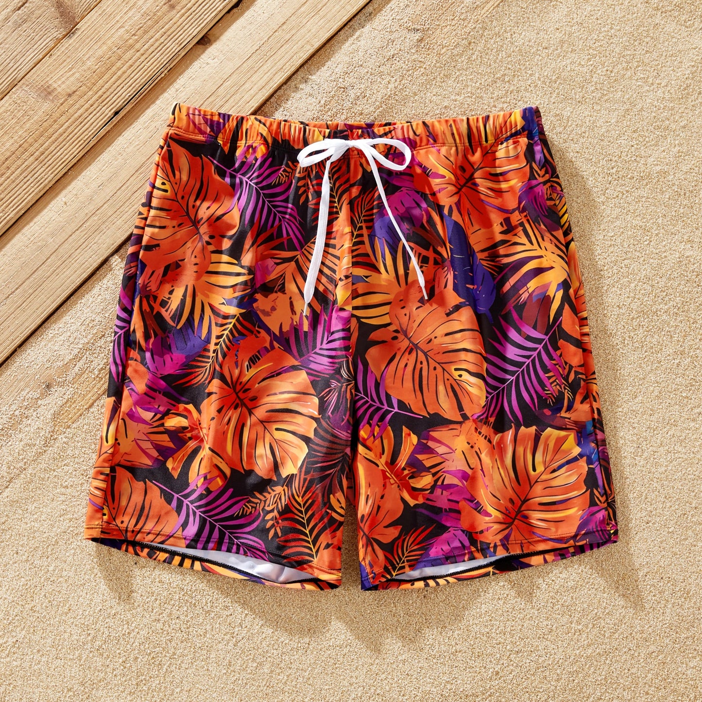 Full family in matching floral print swimwear on a sunny beach vacation.