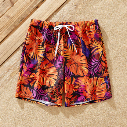 Full family in matching floral print swimwear on a sunny beach vacation.