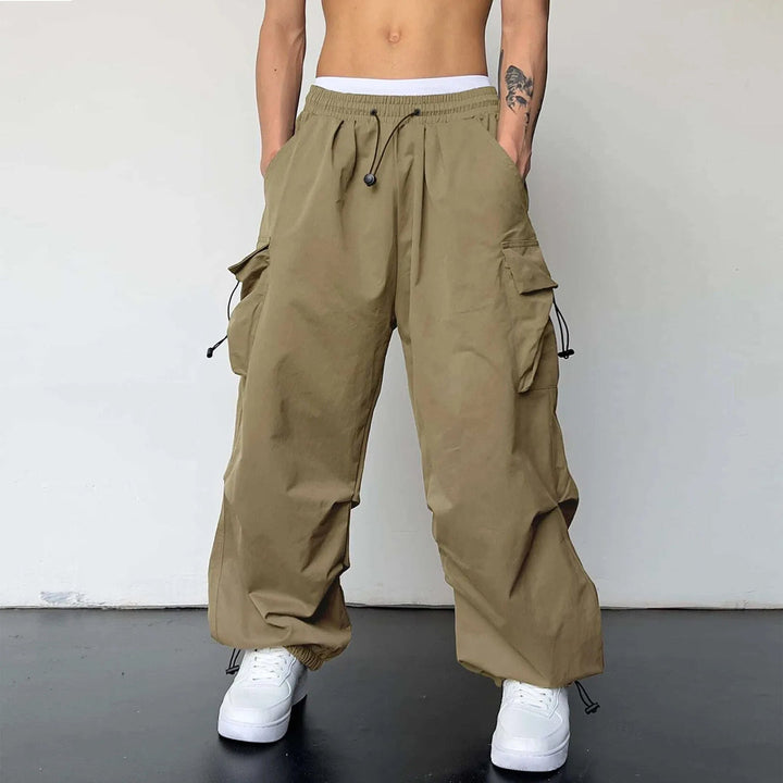 Men's baggy cargo parachute pants with multiple utility pockets. Ideal for comfortable Y2K streetwear fashion.
