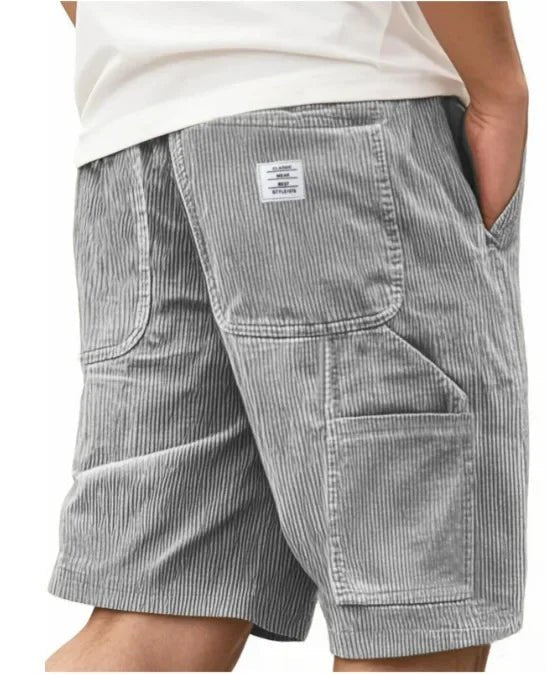 Close-up of cargo pocket on men's relaxed fit shorts, highlighting stitching & durable fabric for outdoor wear.