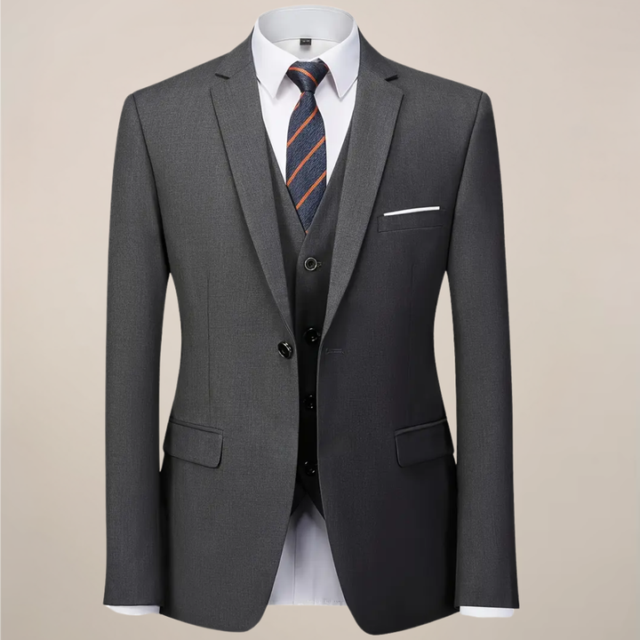 Elegant dark grey slim fit three-piece suit for men. Includes tailored jacket, vest & trousers, ideal for formal attire.