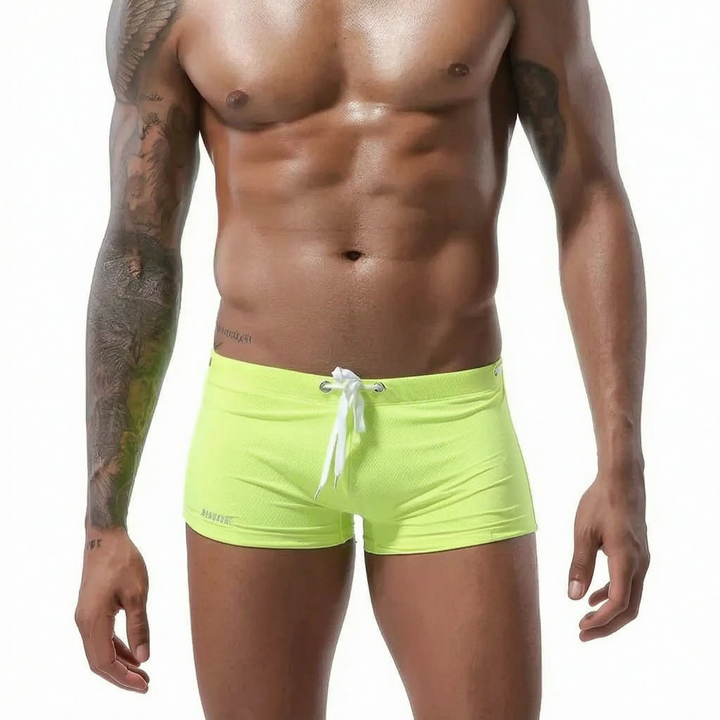 Textured men's low-rise fitted swim trunks, short cut, perfect for active summer swimwear.
