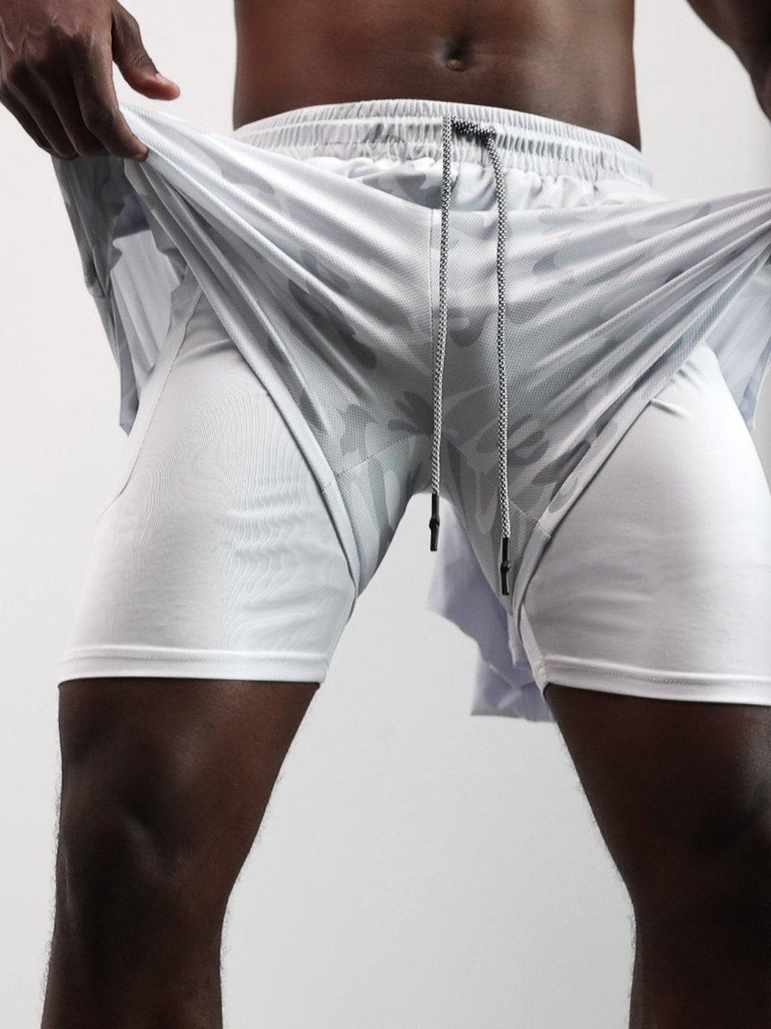 Man models Men's Kinetic Mesh active shorts, showcasing casual & athletic style.
